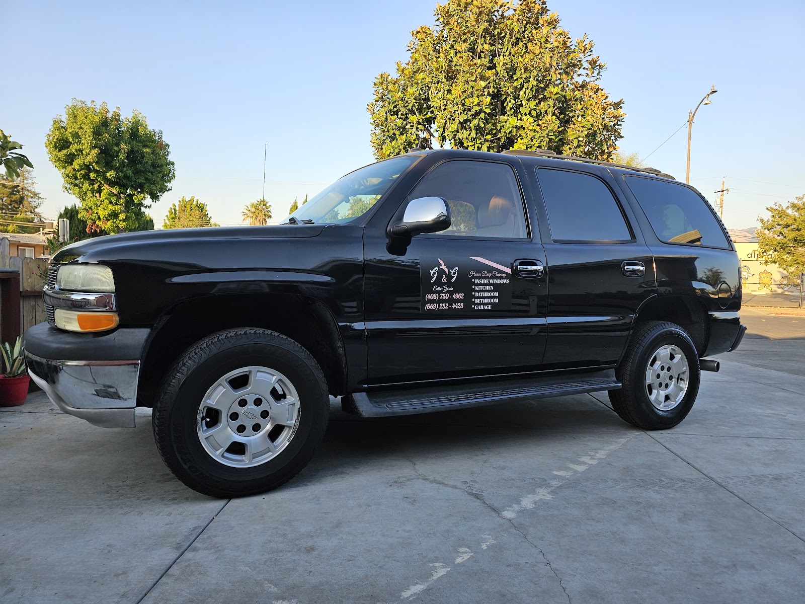Clean black Chevrolet Tahoe with a cleaning-company decal after a wash