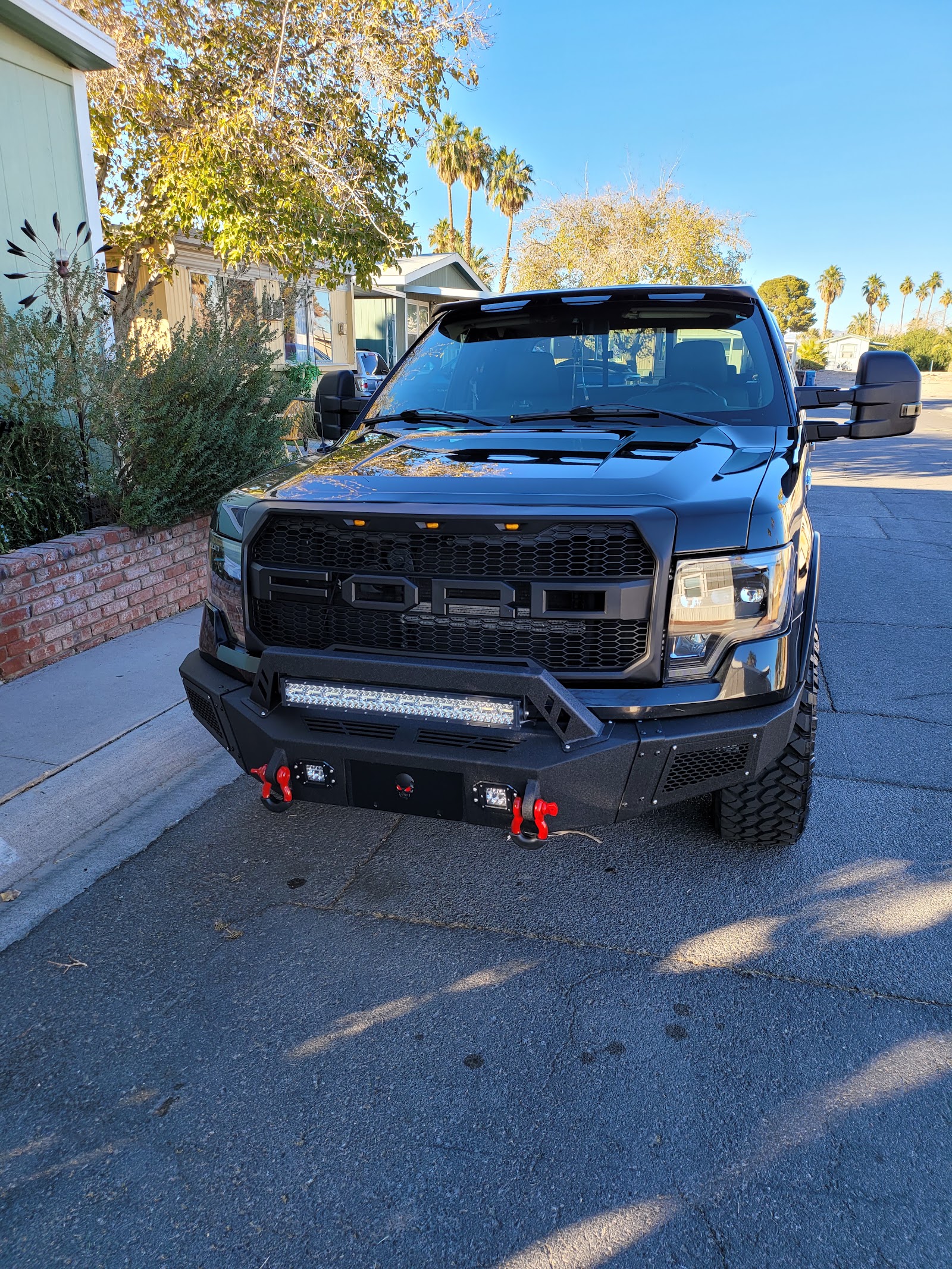 Clean black Ford F-150 with custom bumper and grille after a hand wash
